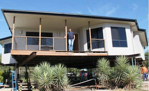 Jim Fabish stands on the balcony of his dream home after it was raised 2.7m in June. Jim Fabish stands on the balcony of his dream home after it was raised 2.7m in June.